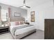 This bedroom boasts a modern gray color scheme, a plush bed with decorative pillows, and a stylish ceiling fan at 7802 Palmilla Ct, Reunion, FL 34747