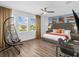 Bright bedroom with a modern hanging chair, sleek desk, and large windows offering outdoor views at 7802 Palmilla Ct, Reunion, FL 34747