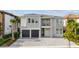 Striking two-story home with a two-car garage, stone veneer, balcony, and stylish gray and white exterior at 7802 Palmilla Ct, Reunion, FL 34747
