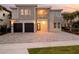Charming two-story home with a paved driveway, stone accents, balcony, and a two-car garage at 7802 Palmilla Ct, Reunion, FL 34747