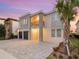 Contemporary two-story house with stone details, a balcony, a two-car garage, and a paved driveway at 7802 Palmilla Ct, Reunion, FL 34747