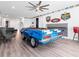 Bright game room featuring a custom-built pool table car, sports memorabilia, and wood-look floors at 7802 Palmilla Ct, Reunion, FL 34747