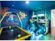 Vibrant game room featuring arcade games, air hockey, and colorful wall art for endless entertainment at 7802 Palmilla Ct, Reunion, FL 34747