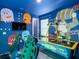 Vibrant game room features custom wall art, an air hockey table, and gaming chairs at 7802 Palmilla Ct, Reunion, FL 34747