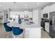 Bright kitchen features a large central island with seating, stainless steel appliances, and ample cabinet storage at 7802 Palmilla Ct, Reunion, FL 34747