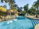 Beautiful lazy river with waterfall feature and lush tropical landscaping on both sides at 7802 Palmilla Ct, Reunion, FL 34747