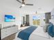 Spacious bedroom with golf course views, a peloton bike, and a mounted flatscreen television at 7802 Palmilla Ct, Reunion, FL 34747