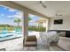 Covered outdoor kitchen and seating area with ceiling fans overlooking the sparkling pool at 7802 Palmilla Ct, Reunion, FL 34747