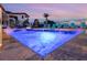 Low angle of a pool with lights and a partial view of the backyard at 7802 Palmilla Ct, Reunion, FL 34747