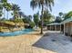 Beautifully landscaped pool area featuring a waterfall, cabanas, and lounge chairs at 7802 Palmilla Ct, Reunion, FL 34747