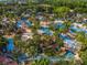 Aerial view of a large water park featuring multiple pools, cabanas, and palm trees at 7802 Palmilla Ct, Reunion, FL 34747