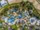 Overhead view of a community water park with pools, slides, and sunbathing areas at 7802 Palmilla Ct, Reunion, FL 34747