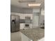 Well-lit kitchen featuring stainless steel appliances, granite counters, and white cabinets at 808 Massy Ct, Kissimmee, FL 34759