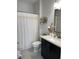Bathroom featuring black vanity with white countertop, decorative mirror, with white shower curtain at 8919 Lakeshore Pointe Dr, Winter Garden, FL 34787