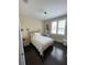Bright bedroom featuring dark wood floors, a cozy bed, and a sunlit window with shutters at 8919 Lakeshore Pointe Dr, Winter Garden, FL 34787