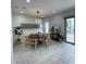 Bright dining room features a round table, modern light fixture, white wainscoting, and neutral tile flooring at 8919 Lakeshore Pointe Dr, Winter Garden, FL 34787
