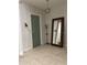 Inviting entryway with stylish light fixture, large mirror, coat rack and tiled floors at 8919 Lakeshore Pointe Dr, Winter Garden, FL 34787