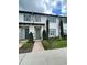 Charming townhome featuring blue shutters and doors, complemented by lush landscaping and a welcoming walkway at 8919 Lakeshore Pointe Dr, Winter Garden, FL 34787