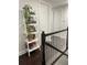 Hallway featuring dark hardwood floors, a white decorative bookcase, and white bannister at 8919 Lakeshore Pointe Dr, Winter Garden, FL 34787