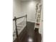 Upstairs hallway featuring dark hardwood floors, white doors, and a decorative bookcase at 8919 Lakeshore Pointe Dr, Winter Garden, FL 34787