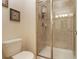 Well-lit bathroom featuring a glass shower, white toilet, and neutral tiling at 8942 Cuban Palm Rd, Kissimmee, FL 34747