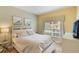 Bright bedroom featuring a comfortable bed, modern decor, and a sunlit window with garden view at 8942 Cuban Palm Rd, Kissimmee, FL 34747