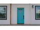 Charming home exterior with a bright turquoise door framed by black framed windows at 9345 Atlanta Dr, St Cloud, FL 34773