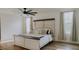 Bright main bedroom with a rustic headboard, neutral tones, and a large ceiling fan at 9345 Atlanta Dr, St Cloud, FL 34773