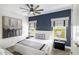 Bedroom with large windows, neutral-toned walls, and a ceiling fan at 1005 Coyote Creek Way, Reunion, FL 34747