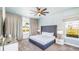 Bedroom with white bedding, ceiling fan and ample natural light at 1005 Coyote Creek Way, Reunion, FL 34747
