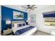 This bedroom offers bright blue walls, carpeted floors, a ceiling fan, and picturesque artwork at 1005 Coyote Creek Way, Reunion, FL 34747