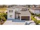 Aerial view of a two-story home with a tile roof, brick accents, and a brick paver driveway at 1005 Coyote Creek Way, Reunion, FL 34747