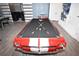 A custom pool table made from a car with wall art and foosball table is featured at 1005 Coyote Creek Way, Reunion, FL 34747