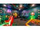 A gamer's paradise featuring neon wall art, gaming chairs, and arcade style games at 1005 Coyote Creek Way, Reunion, FL 34747