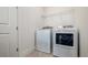 Well-lit laundry room with modern white washer and dryer for efficient laundry care at 1005 Coyote Creek Way, Reunion, FL 34747
