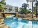 Scenic lazy river with floating tubes, lush landscaping, palm trees, and bridge adding charm to the landscape at 1005 Coyote Creek Way, Reunion, FL 34747