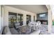 Elegant covered patio with outdoor kitchen, TV, comfortable seating, and large sliding glass doors to the home's interior at 1005 Coyote Creek Way, Reunion, FL 34747