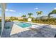 The luxurious pool is surrounded by palm trees, lounge chairs, and a beautiful patio at 1005 Coyote Creek Way, Reunion, FL 34747