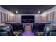 Home theater room with tiered seating, black leather recliners and a large projection screen at 1005 Coyote Creek Way, Reunion, FL 34747