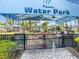Water park entrance featuring picnic tables under shady umbrellas within a gated entrance to the park at 1005 Coyote Creek Way, Reunion, FL 34747