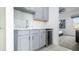 A stylish wet bar with grey cabinetry, a wine fridge and quartz countertops at 1005 Coyote Creek Way, Reunion, FL 34747