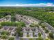 Aerial view of the townhome community featuring a small lake and a wooded perimeter at 10746 Regent Square Dr # 1502, Orlando, FL 32825