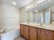 Bathroom featuring a double vanity with a soaking tub and a walk-in shower with tiled flooring at 10746 Regent Square Dr # 1502, Orlando, FL 32825