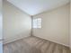 A carpeted bedroom with a window, with neutral colored walls and trim throughout, and a double electric outlet at 10746 Regent Square Dr # 1502, Orlando, FL 32825