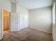 A carpeted bedroom with a large closet and a window, with neutral colored walls and trim throughout at 10746 Regent Square Dr # 1502, Orlando, FL 32825
