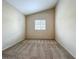 A carpeted bedroom with a window, with neutral colored walls and trim throughout, and a double electric outlet at 10746 Regent Square Dr # 1502, Orlando, FL 32825