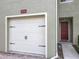 Garage with red front door to the right of the garage and walkway to the entry at 10746 Regent Square Dr # 1502, Orlando, FL 32825