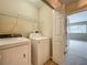 A laundry room with a washer and dryer and wire shelving, with a doorway leading into a bedroom at 10746 Regent Square Dr # 1502, Orlando, FL 32825