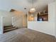This open living room features new carpet and a staircase to the second floor next to a kitchen at 10746 Regent Square Dr # 1502, Orlando, FL 32825