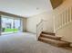 This open living room features new carpet, large slider doors, and a staircase to the second floor at 10746 Regent Square Dr # 1502, Orlando, FL 32825